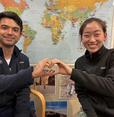 Two people making a heart shape with their hands